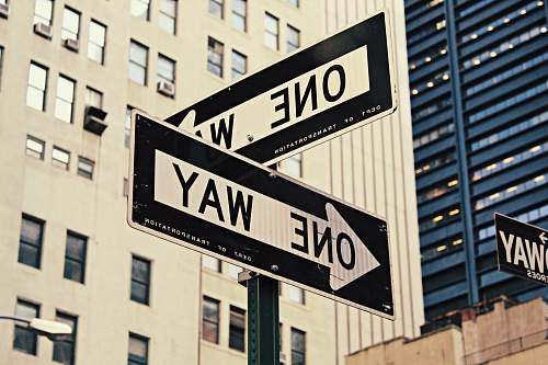 street sign white and black One Way-printed road signages one way